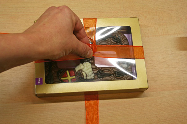 Holiday Gift Wrapping: How to tie ribbon around a gift box. Holding Ribbon Around a Gift Box