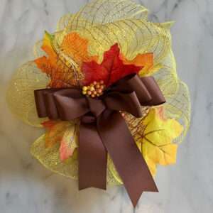 Hot Glue Artificial Leaves and Berries to the Bows